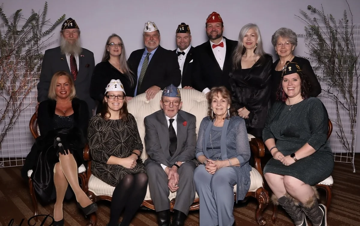 A group gathered for a formal occasion, with several people wearing American Legion caps