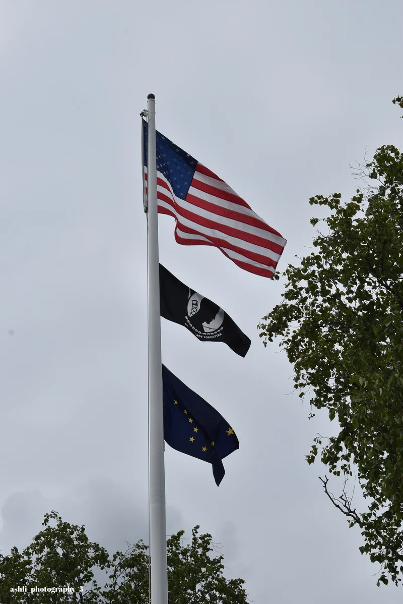 American, POW/MIA, and Alaska flags flying at Jack Henry Post 1
